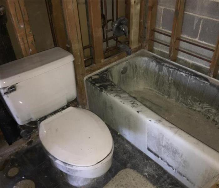 Soot covered bathtub and toilet.
